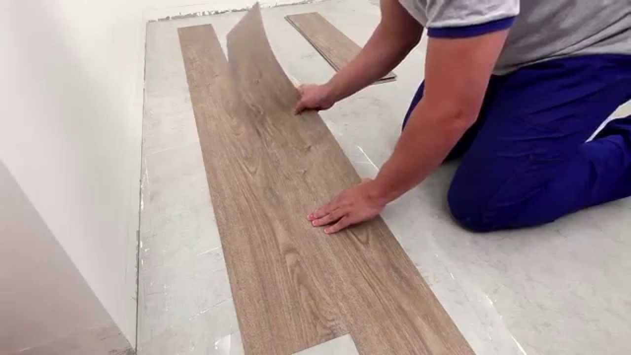homem instalando piso vinilico marrom