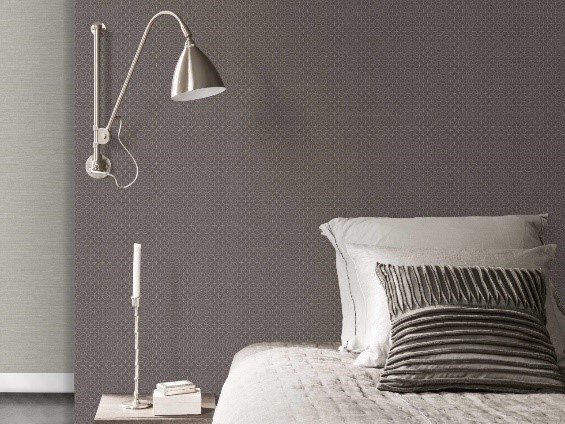 cama branca com lâmpada ao lado, com parede de vinílico marrom atrás